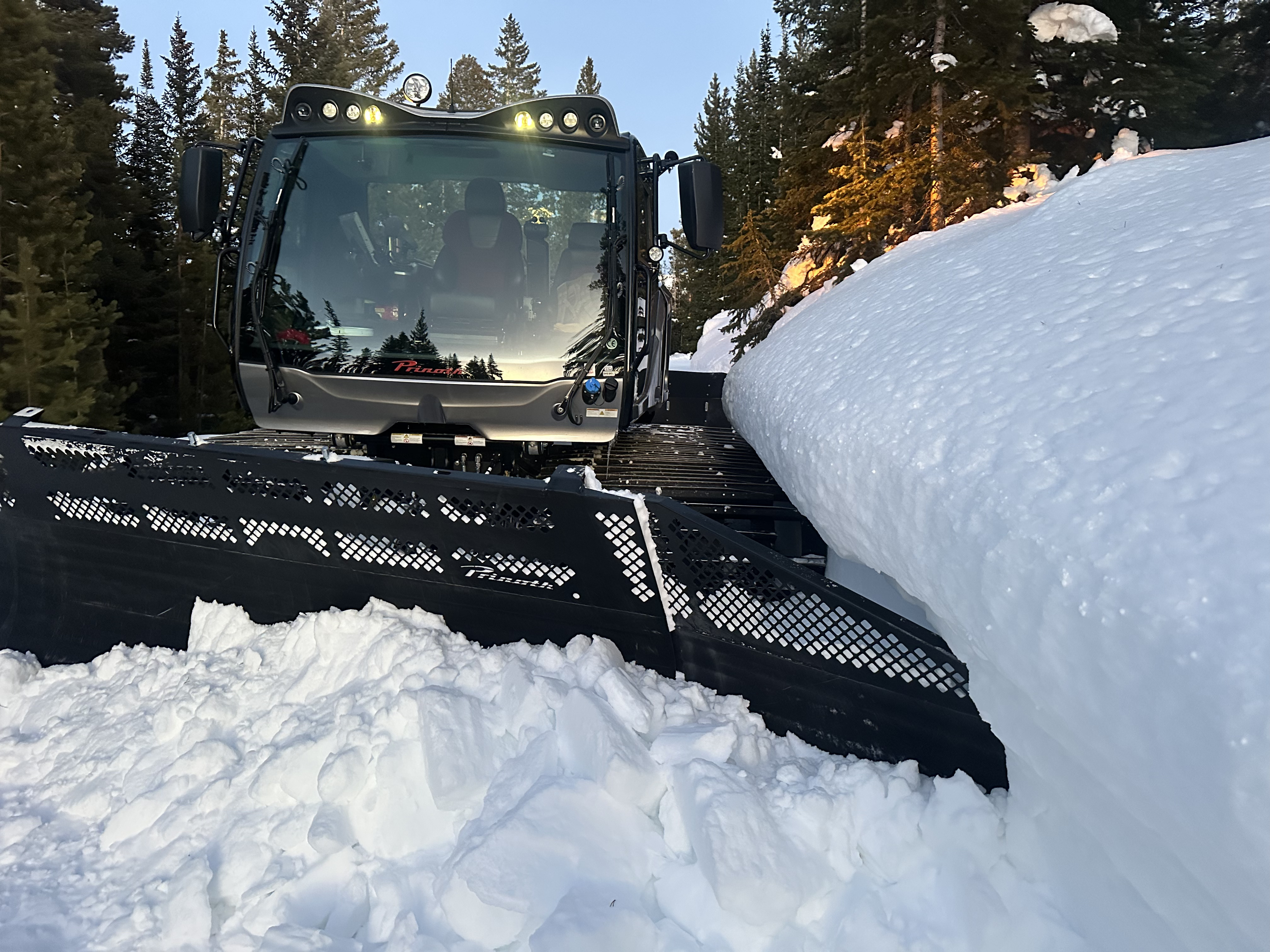Prinoth snowcat pushing deep snow on a mountain road in Colorado